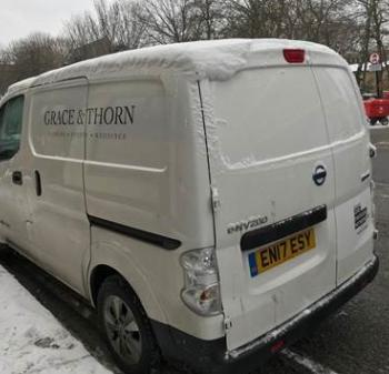 White van in snow with Grace and Thorn written on the side