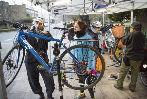 Bike mechanic fixes bike for Woman