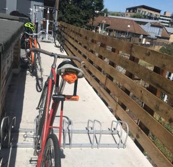 a red and orange bike parked in the sunshine 